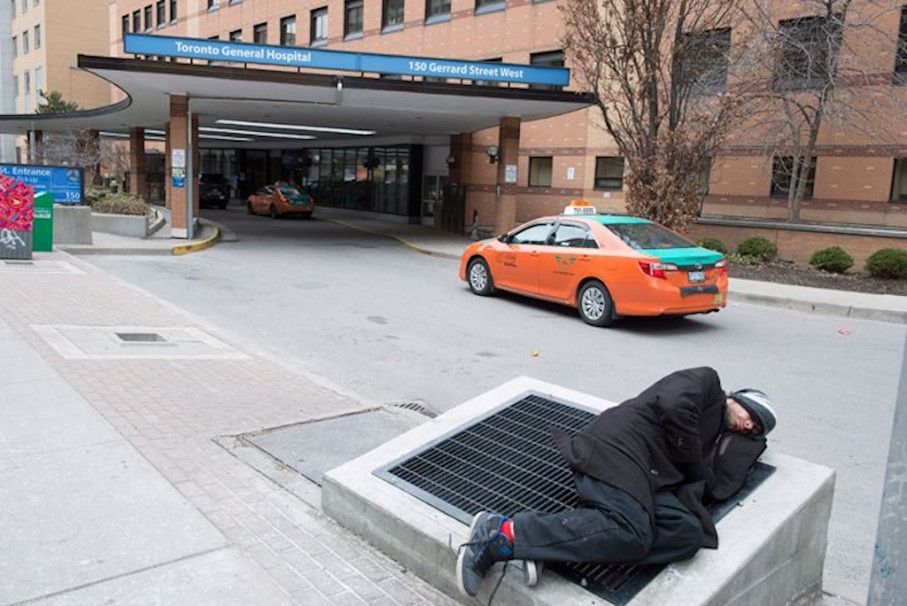 A homeless man sleeping rough in front of Toronto General Hospital