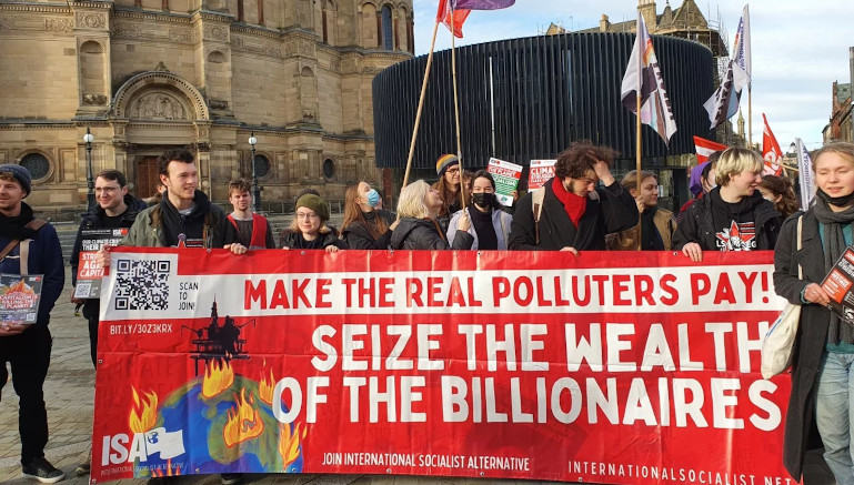 ISA comrades holding a banner with the slogan, "make the real poluters pay - seize the wealth of the billionaires"